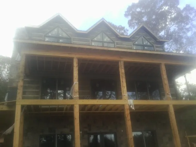 Dormers and porch framing on a large log home under construction — Roof Coating work by our crew in Bryant